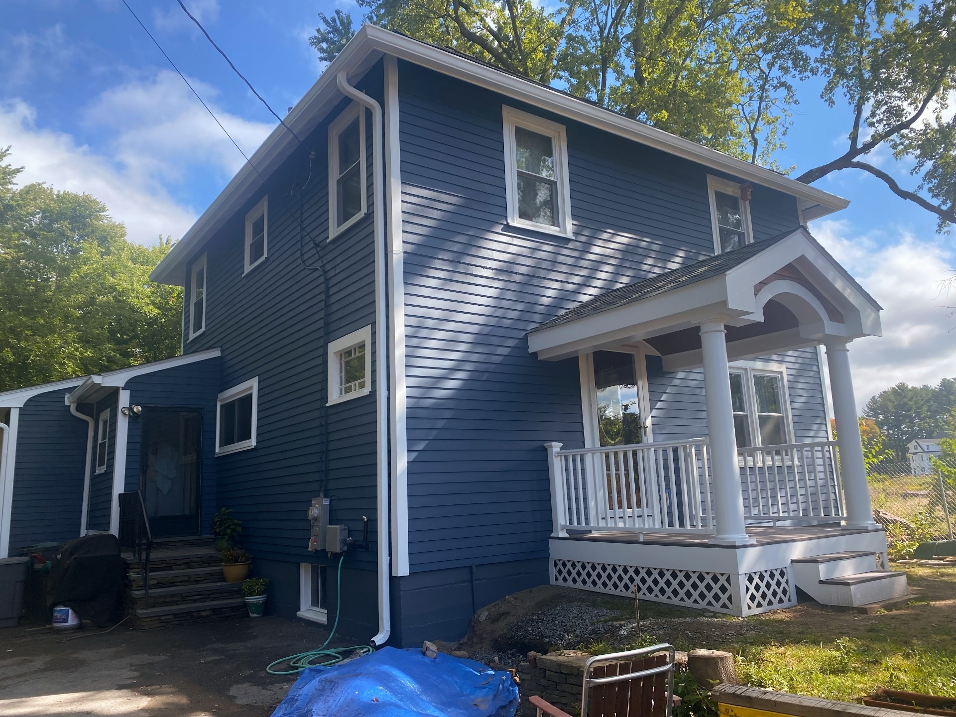 Exterior painting of two-story home in navy blue with white trim by Lima Painting in Greater Boston MA