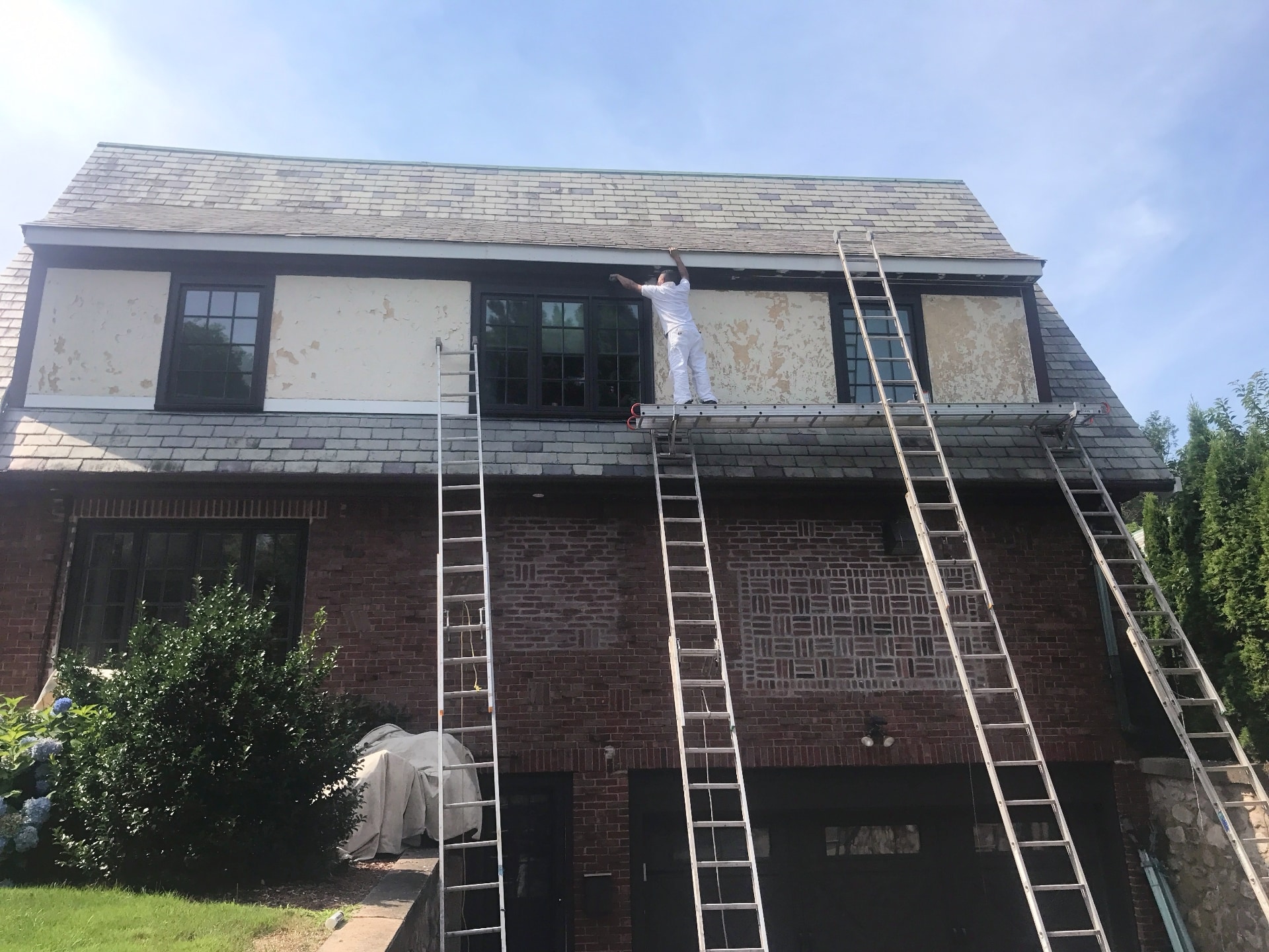 Lima Painting crew scraping and prepping exterior siding on large home before painting in Greater Boston MA