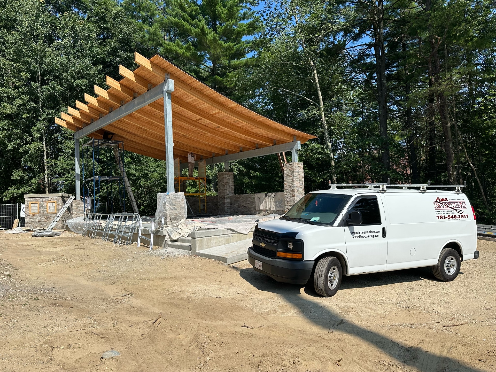 Lima Painting work van parked outside large commercial exterior staining project