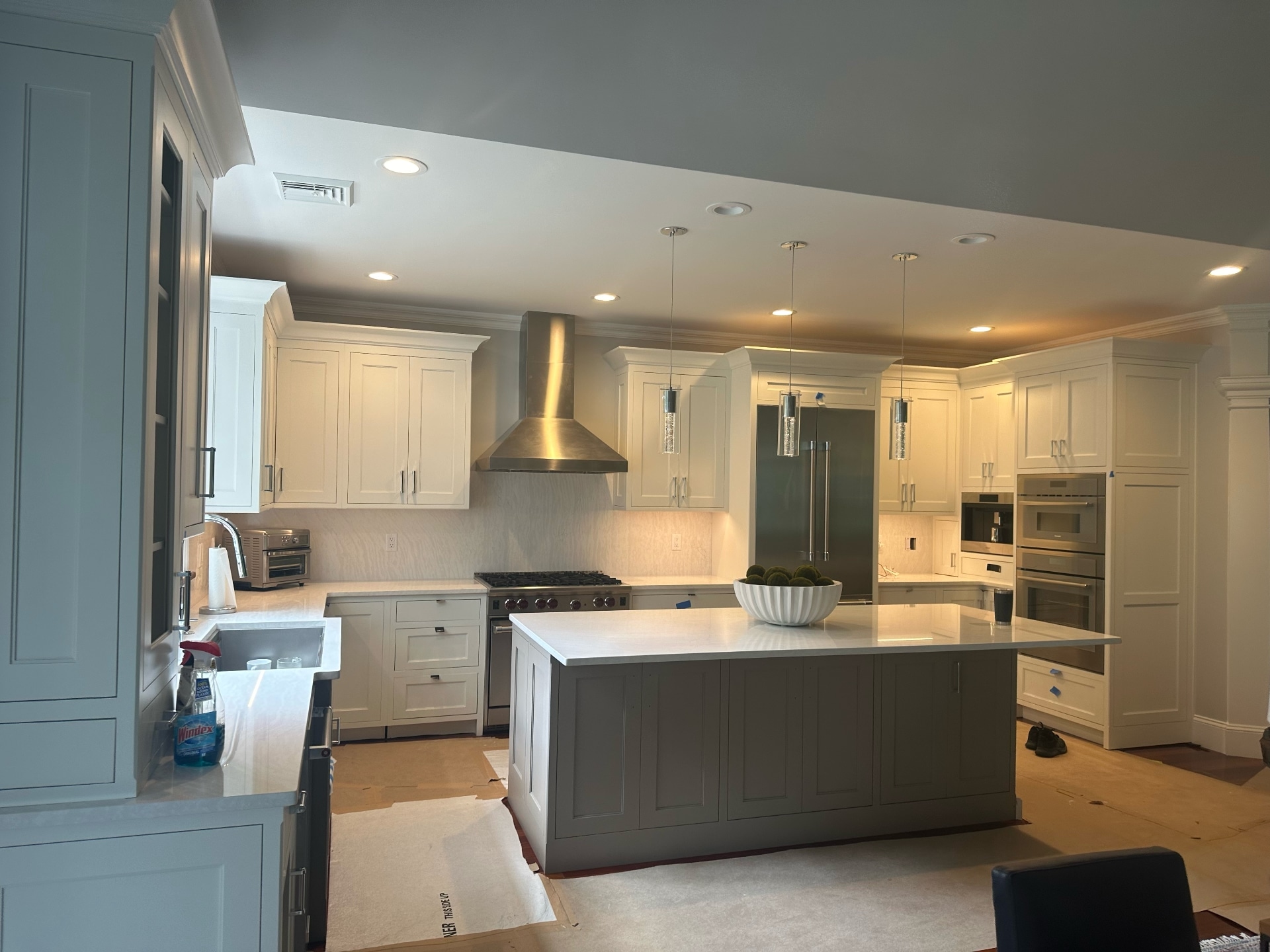 Luxury kitchen interior with painted white cabinets and gray island by Lima Painting in Greater Boston MA