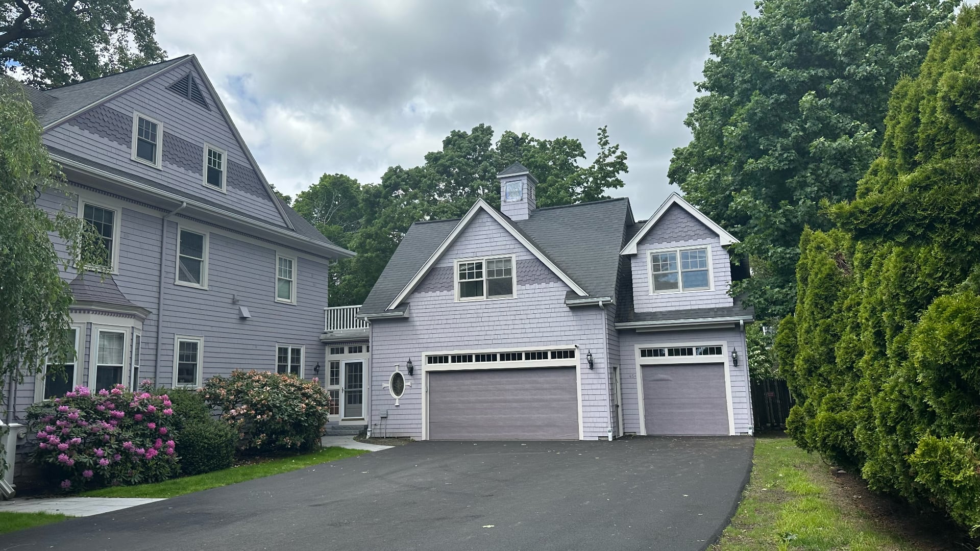 Side view of exterior painted Victorian home with three-car garage in lavender gray by Lima Painting in Greater Boston